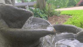 In this video the water is flowing over atwo tiered  bird bath with sparkling reflections.