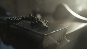 Holy Bible and prayer beads with cross in Christian church closeup. Psalmbook and rosary on wooden desk in temple closeup. Religious worship symbols concept - Powered by Shutterstock - Get 15% off with code: PIKWIZARD15