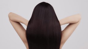 Slow motion rear view of young Asian girl shakes long straight hair. Female model is fluttering hair. - Powered by Shutterstock - Get 15% off with code: PIKWIZARD15