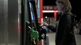 a woman at a gas station presses a pin code at pay machine, wants to pay - Powered by Shutterstock - Get 15% off with code: PIKWIZARD15