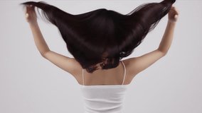 Slow motion rear view of young Asian girl shakes long straight hair. Female model is fluttering hair. - Powered by Shutterstock - Get 15% off with code: PIKWIZARD15