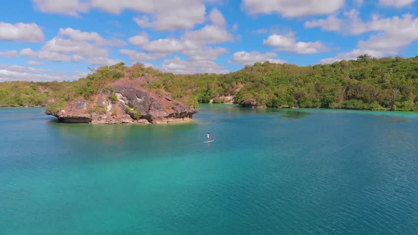 Aerial view of a man on a surfboard in beautiful turquoise waters