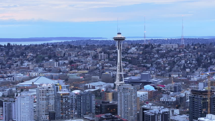 The Seattle skyline at dusk captures the essence of the city, with the Space Needle prominently in view against the backdrop of a bustling urban area and fading light. 4K footage. 