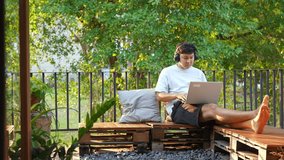 Asian man working on laptop computer with using AI browsing data at home. Male freelance sitting at balcony and working online corporate business. Modern life and remote working technology concept. - Powered by Shutterstock - Get 15% off with code: PIKWIZARD15