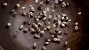 Organic dried blue corn kernels for making popcorn falling into a rustic wooden bowl in slow motion. Dry Mexican Hopi maize grains - Powered by Shutterstock - Get 15% off with code: PIKWIZARD15