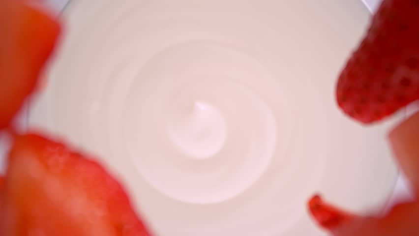 Super Slow Motion Shot of Fresh Strawberries Followed by Camera Falling into Yogurt at 1000fps.