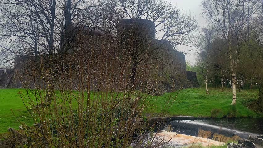 Calm shot of Athenry Castle with little cascade in the foreground.