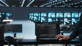 IT support employee writing code on laptop in high tech facility with server rows providing computing resources for different workloads. System administrator uses notebook to oversee supercomputers - Powered by Shutterstock - Get 15% off with code: PIKWIZARD15