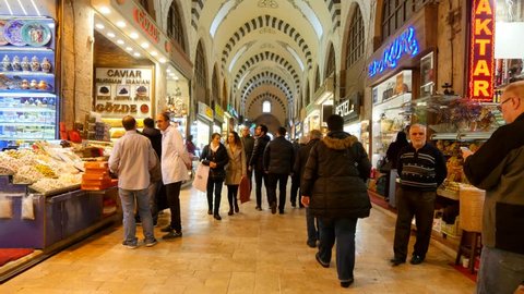 ISTANBUL - JAN 8, 2018: Walking dolly shot of indoor shops and interior architecture of the old traditional Spice Market. Egyptian Bazaar. People shopping inside the arcade one of the oldest market in