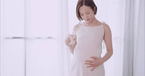 Asian pregnant woman drinking milk for the health of herself and her unborn baby. Arkivvideo