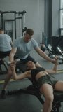 Vertical shot of fitness trainer helping woman with doing dumbbell chest press on gym bench during workout - Powered by Shutterstock - Get 15% off with code: PIKWIZARD15