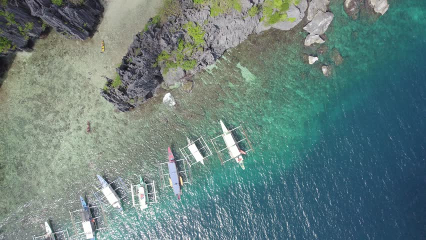 Aerial view of the amazing Big Lagoon in El Nido, Palawan, Philippines. Shallow lagoon with blue water amid jagged Karst Rock cliffs and lush tropical jungle. Royalty-Free Stock Footage #3497226431