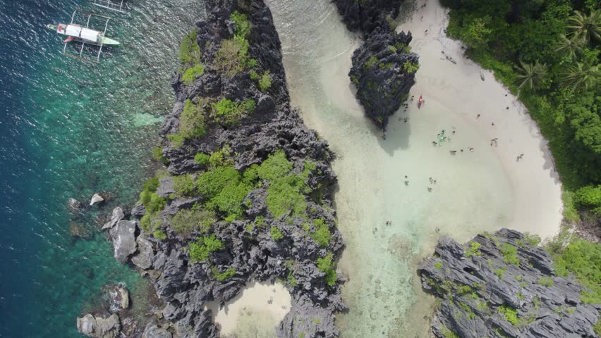 Aerial view of the amazing Big Lagoon in El Nido, Palawan, Philippines. Shallow lagoon with blue water amid jagged Karst Rock cliffs and lush tropical jungle. Royalty-Free Stock Footage #3497226793