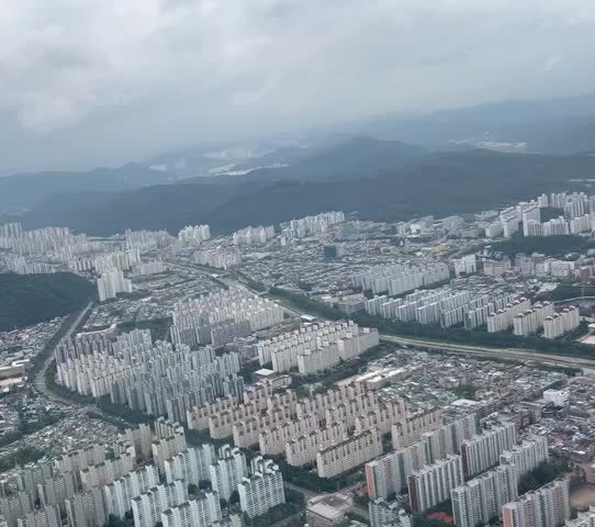 Aerial view of Busan City, South Korea, East Asia full of apartment buildings, offices, and green hill