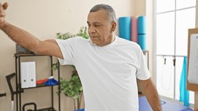 A middle-aged man flexing muscles smilingly in a healthcare rehabilitation center's bright room. - Powered by Shutterstock - Get 15% off with code: PIKWIZARD15