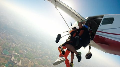Jump skydiving. Two crazy young men Tandem jumping from the plane on a summer day in Italy. Very extreme 