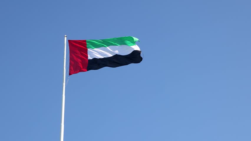 UAE flag waving in the blue sky, national symbol of UAE. High quality 4k footage.