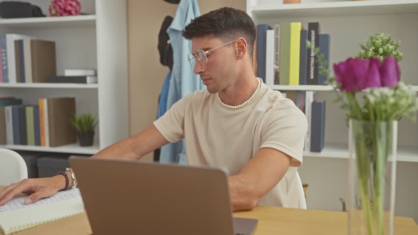 A young hispanic man experiencing headache while working on a laptop at his modern home office setup. Royalty-Free Stock Footage #3497322437