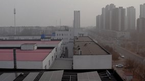 Solar panels installed on the roof provide the factory with clean energy. Industrial zone in Tianjin, China. Residential communities near factories provide housing for workers. Smog and air pollution - Powered by Shutterstock - Get 15% off with code: PIKWIZARD15