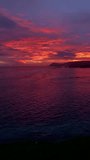 Vertical Video 4K Ocean during sunset. Coast, sky, water, sun from beach hill.
