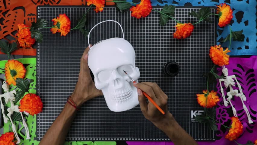 Hands painting white skull with vibrant flowers for Day of the Dead, top view, crafting concept Royalty-Free Stock Footage #3497479241