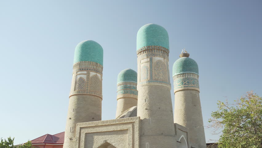 Awesome view of Chor Minor (the Madrasah of Khalif Niyaz-kul) in Bukhara, Uzbekistan. The historic gatehouse with four towers is a popular tourist attraction of Central Asia.