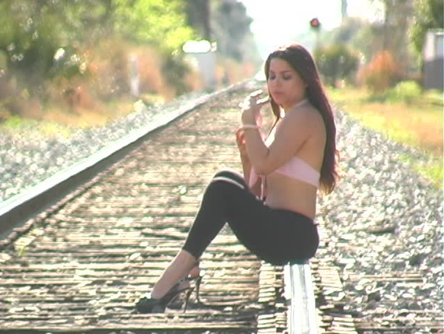 A native-American beauty sitting alone on an empty stretch of railroad track with a rare albino corn snake.  This clip can be used alone or extended frame-accurately by adding 1b.