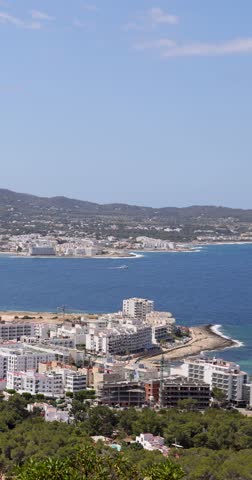 Portrait aerial footage of the town of Sant Antoni de Portmany on the west coast of Ibiza, one of Spain’s Balearic Islands, showing the ocean front by the hotels in the town centre in the summer time.
