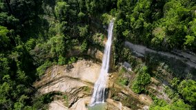 4K Aerial Drone video of epic tall waterfalls falling to rocks in canyon surrounded by jungle, Can-Umantad Falls in Bohol, Philippines