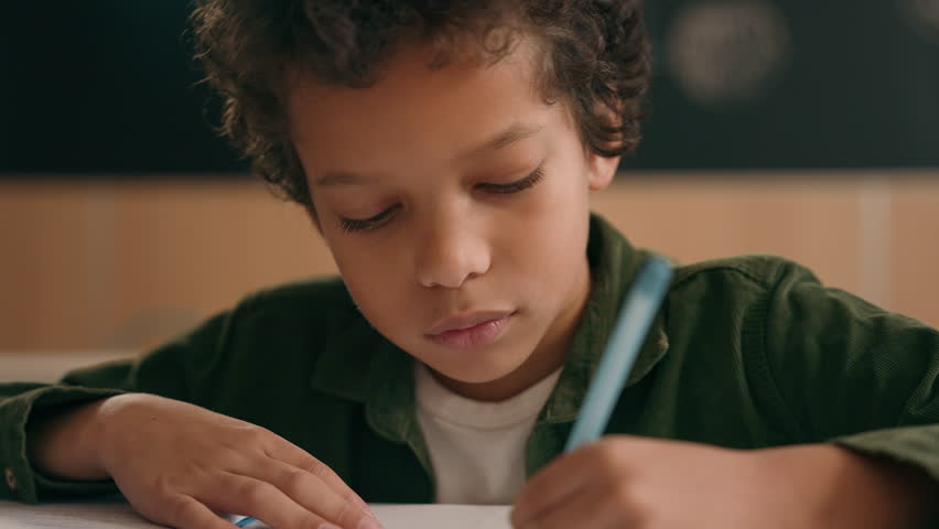 African American school boy son child ethnic guy little kid schoolboy pupil student writing task write copybook study learn elementary primary education studying learning languages math class lesson