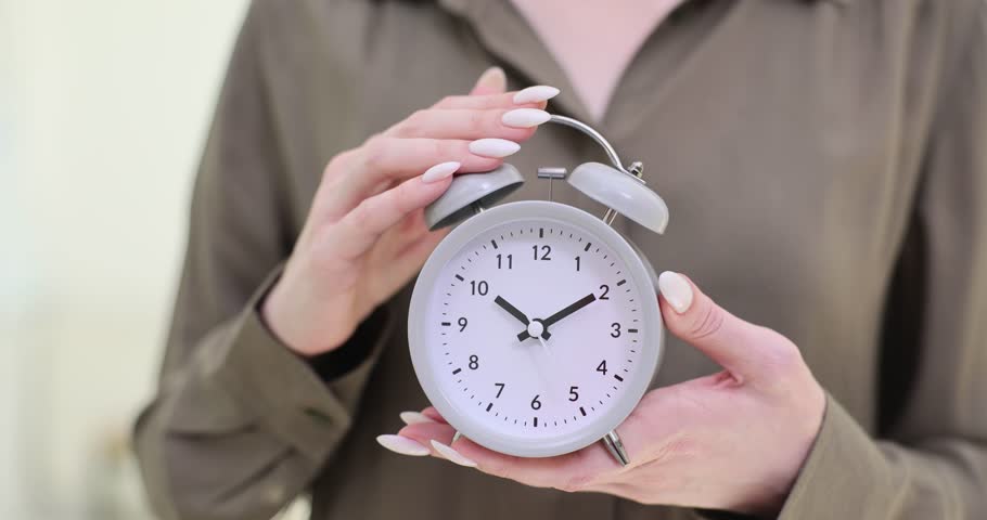 Woman holds stylish alarm clock emphasizing importance of daily routine. Lady reflects essence of effective time management for success