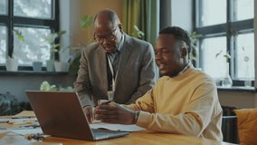 African American senior professor helping young male student using laptop and taking notes during class in college - Powered by Shutterstock - Get 15% off with code: PIKWIZARD15