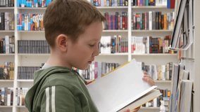 A cute boy takes a book from the stand of a library or book shop and leaves - Powered by Shutterstock - Get 15% off with code: PIKWIZARD15