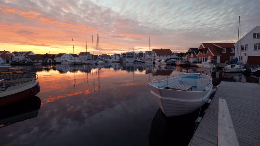 Amazing embankment and seaport. Water transport, yachts, ships, boats, white great private houses on the seashore. Typical European seascape. Beautiful nature at sunset. Red and yellow sky at sunset