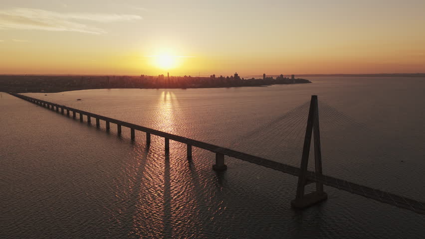 Drone shot back of the San Roque González de Santa Cruz International Bridge at sunset and panoramic horizon, Argentina. Bridge over the Paraná River.