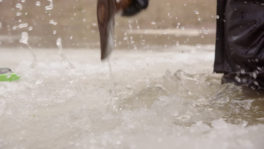 Telephoto slomo of ice diver smashing edge of lake ice to open entry point