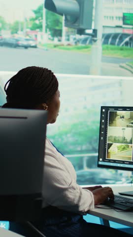 Vertical Video African american employee gathers data on cars in traffic through red light radar CCTV system, using real time surveillance footage for government safety activity. Camera B.