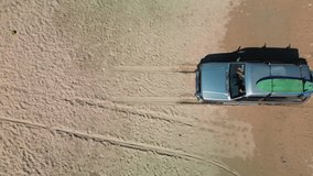 Aerial top view of the trash beach by the sea in Nha Trang at sunset,Cam Ranh, Vietnam. Top down view of a car with boards on the roof for surfing, car drives along the sand on the beach on the sea - Powered by Shutterstock - Get 15% off with code: PIKWIZARD15