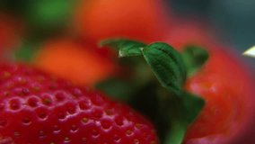 Macro detailed video of a pile of strawberries, red RAW strawberry, green leaf, tiny seeds, on a rotating stand, smooth movement, slow motion 120fps. studio lighting, Full HD