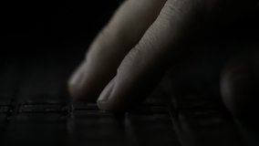 finger pressing computer keyboard. Male hand is writing text on a laptop macro. Fingers pressing keyboard key on black background - Powered by Shutterstock - Get 15% off with code: PIKWIZARD15