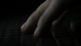 Finger pressing computer keyboard. Male hand is writing text on a laptop macro. Fingers pressing keyboard key on black background - Powered by Shutterstock - Get 15% off with code: PIKWIZARD15