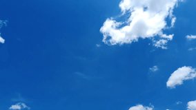 Time-lapse video of moving white clouds in a blue sky.