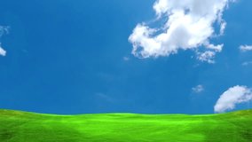 Time lapse video of moving white clouds in a blue sky in a meadow for use as a natural background.