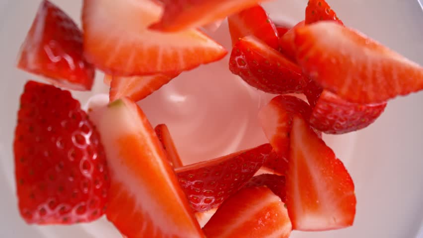 Super Slow Motion Shot of Fresh Strawberries Followed by Camera Falling into Yogurt at 1000fps.