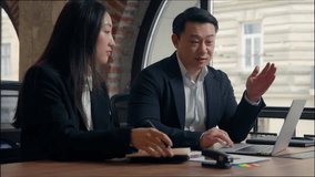 Two Asian business colleagues talking discuss online task computer work Korean man businessman teach using laptop corporate software Japanese Chinese businesswoman intern woman writing notes in office - Powered by Shutterstock - Get 15% off with code: PIKWIZARD15