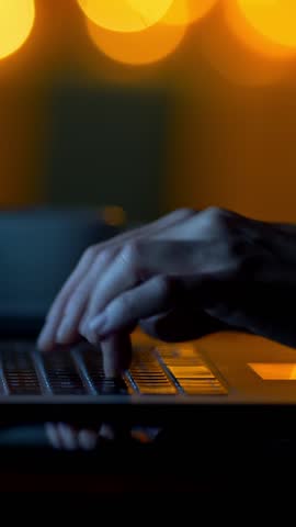 Typing massage text on laptop at night. Female working laptop in dark room. Vertical shot