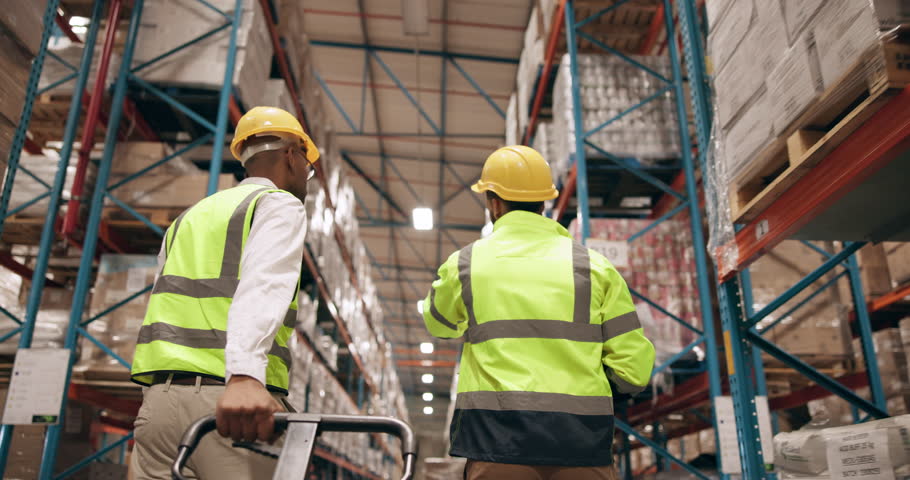 Inventory, teamwork and logistics with men in factory together for stock or supply chain distribution. Collaboration, delivery and trolley with people in warehouse for export shipping from back