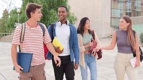 Four teenage real students walking, smiling and talking together at university campus. Group of young friends having a conversation on a social meeting. Multiracial people chatting on a gathering - Powered by Shutterstock - Get 15% off with code: PIKWIZARD15