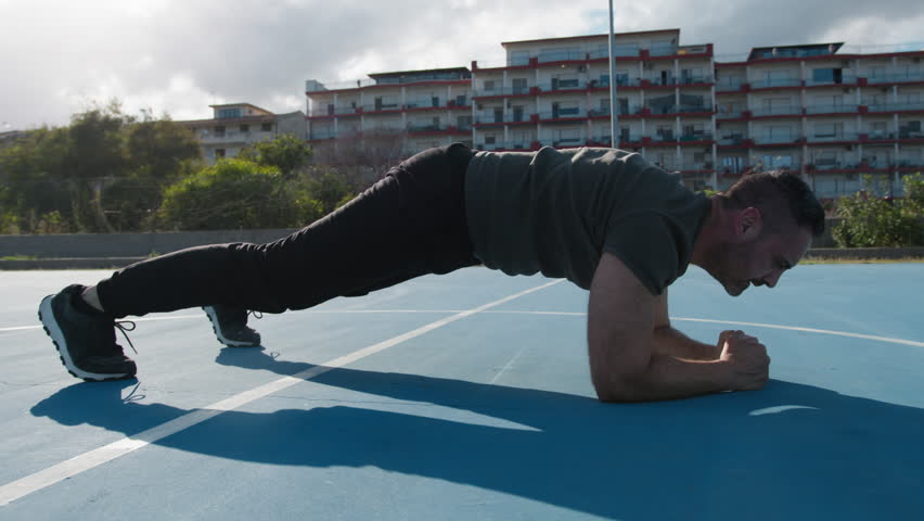 Man Does Bridge For Abs Outdoors In Blue Field