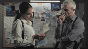 police detectives standing in office working on criminal case,couple of investigators examine files evidences discuss about crime investigation - Powered by Shutterstock - Get 15% off with code: PIKWIZARD15